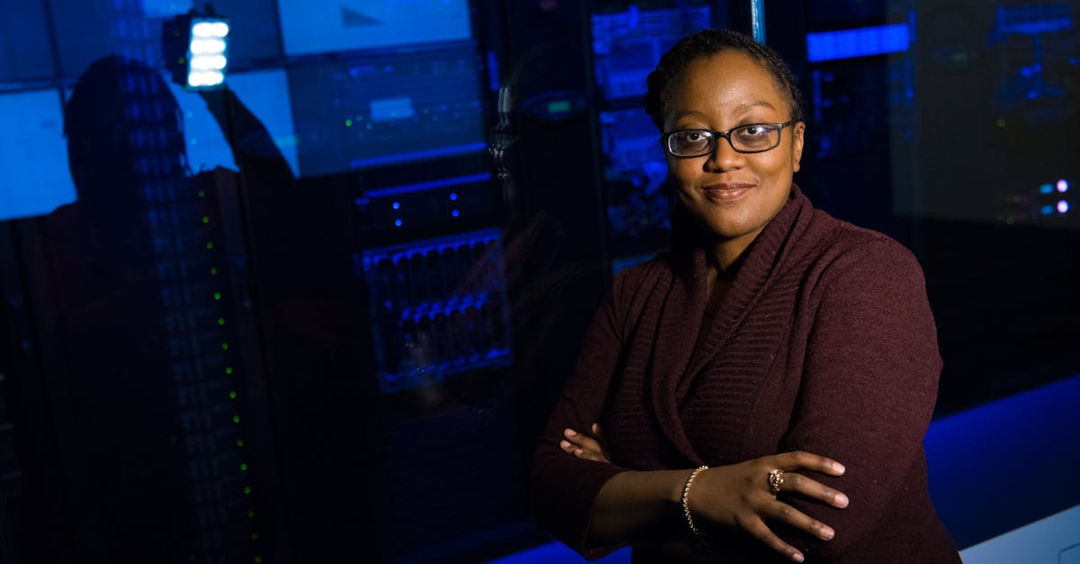 Professional woman standing confidently in a data center, surrounded by glowing servers.